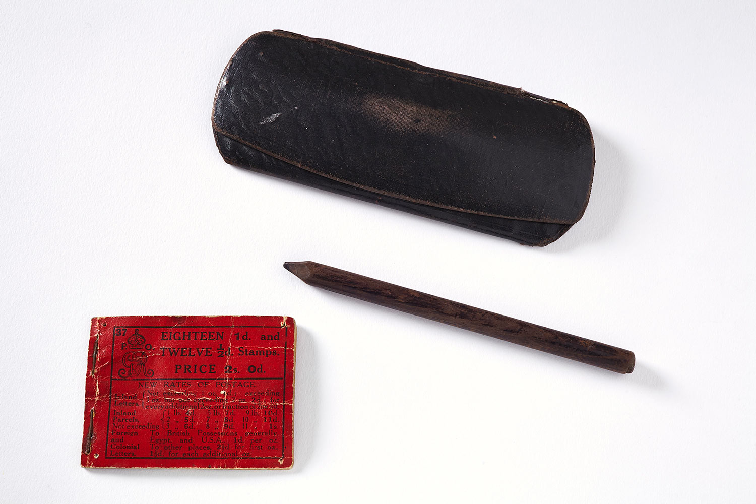 Contents of Tom Clarke’s Pocket, a pencil, a book of stamps and a glasses case