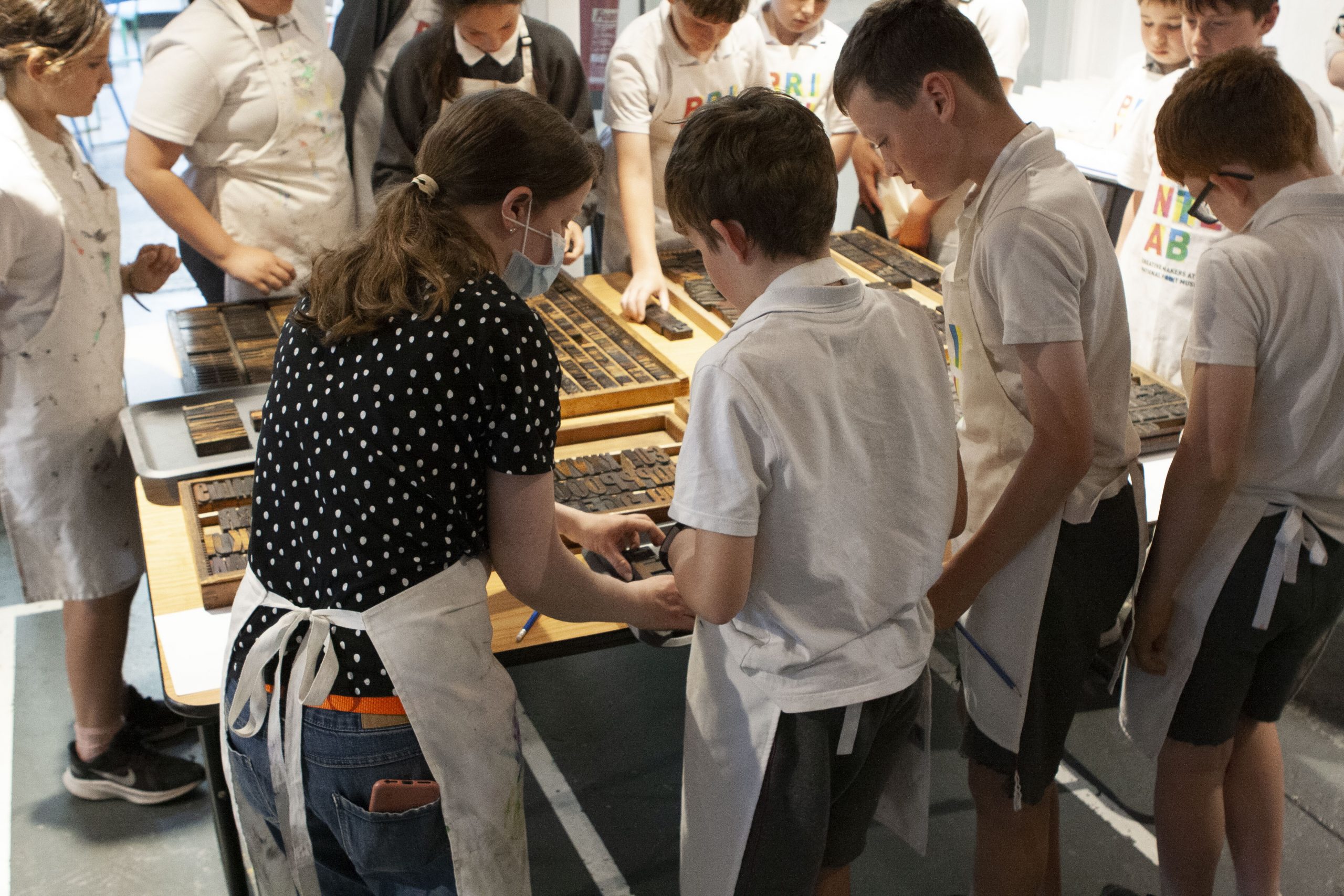 Mary Plunkett setting up text with students using wooden letters.