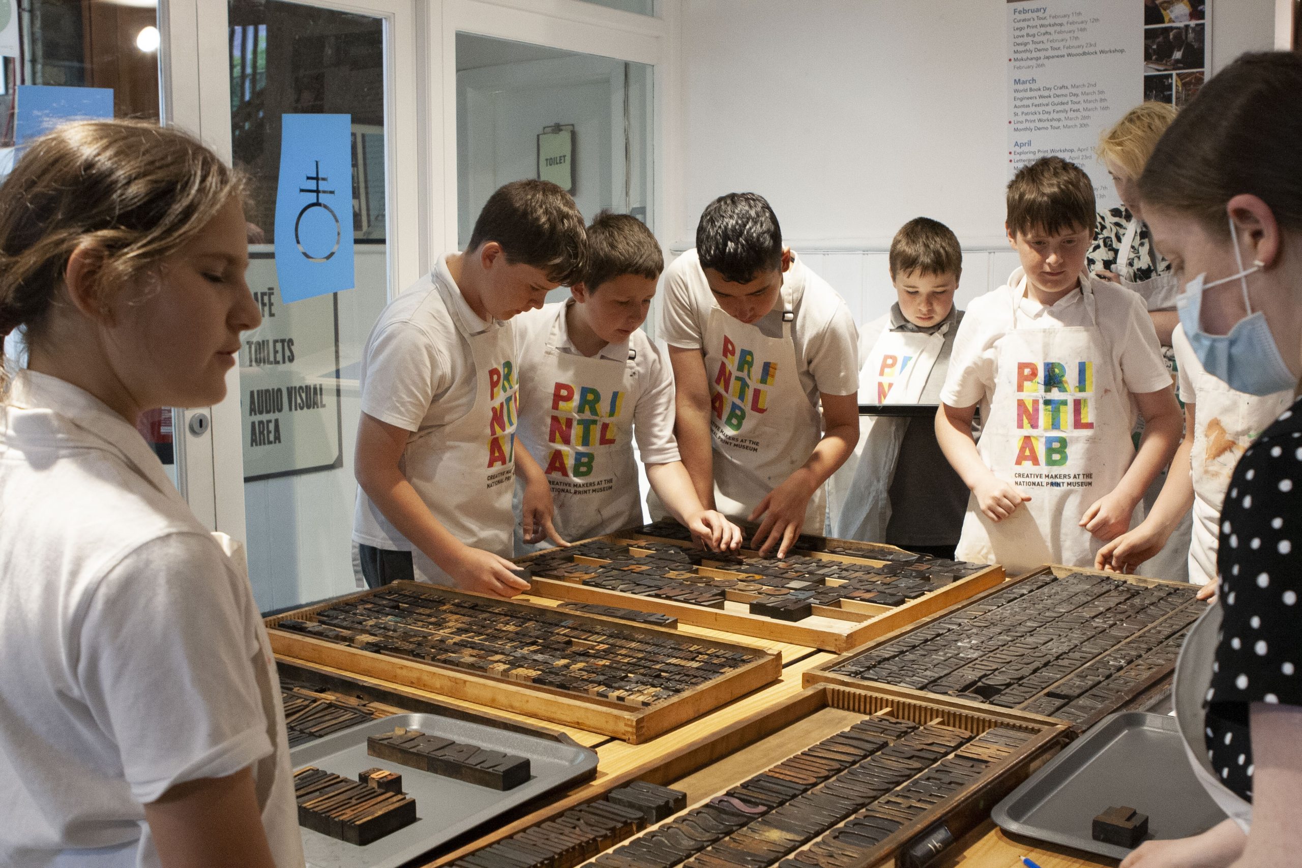 Mary Plunkett setting up text with students using wooden letters.