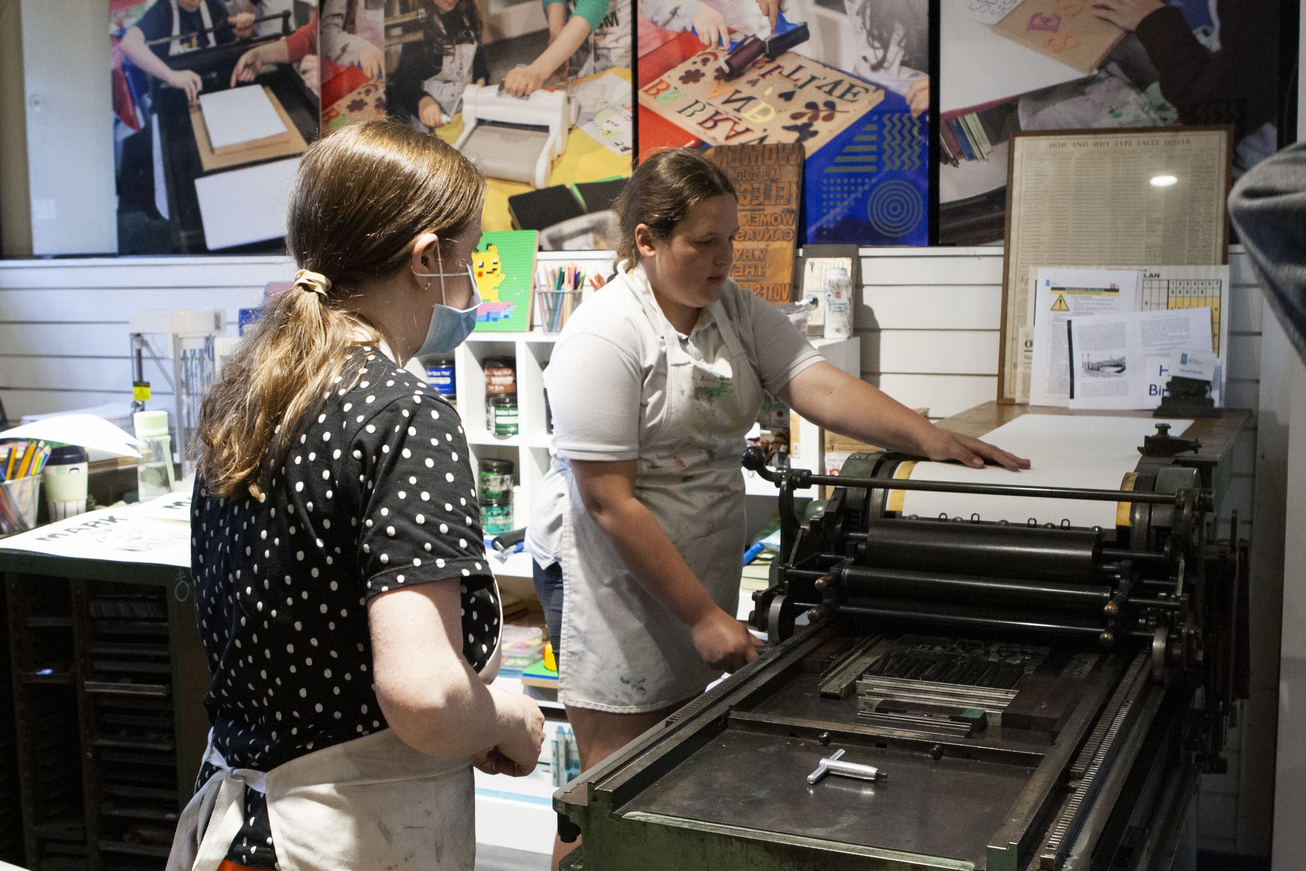 Student using letterpress to print poster.