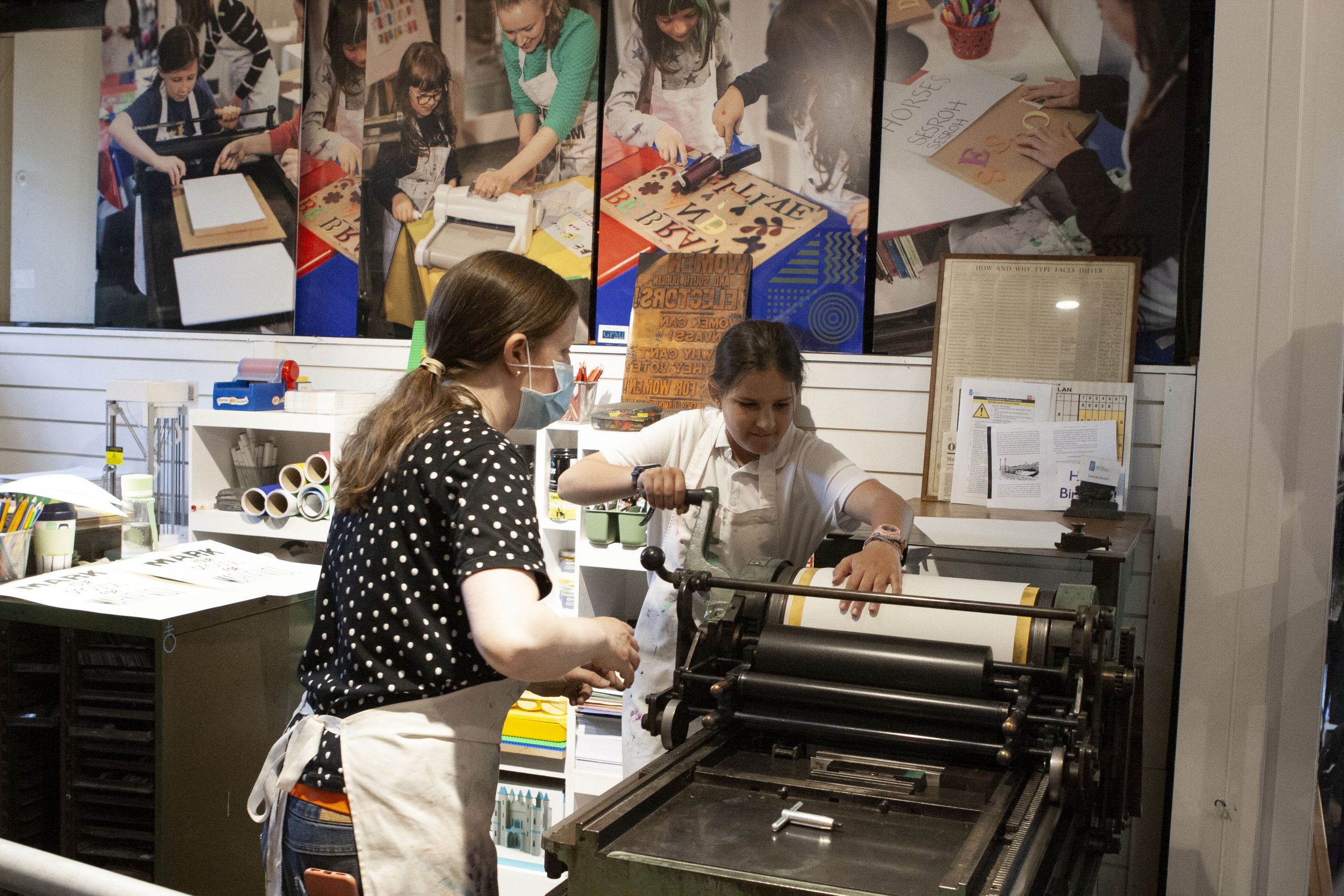 Student using letterpress to print poster.