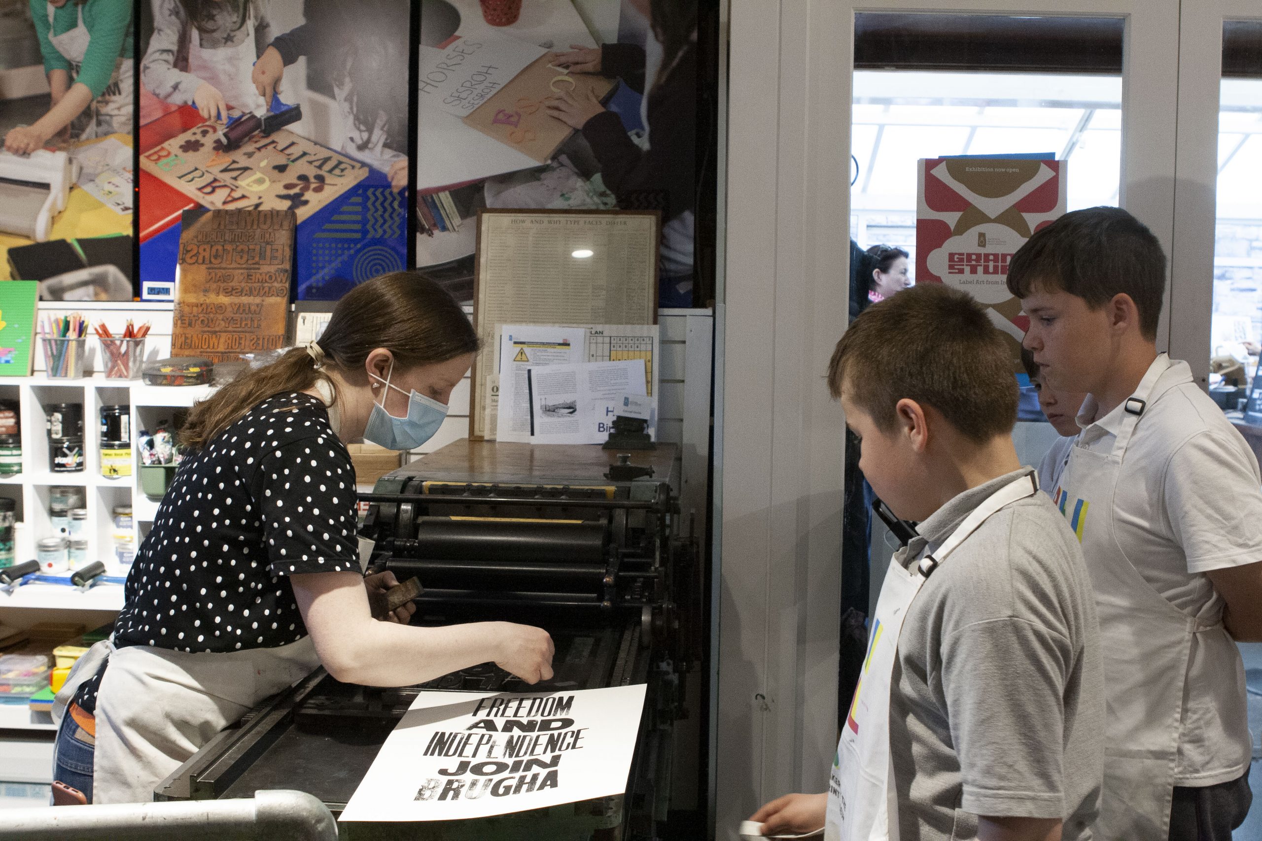 Mary Plunkett showing students how to use the letterpress for printing.